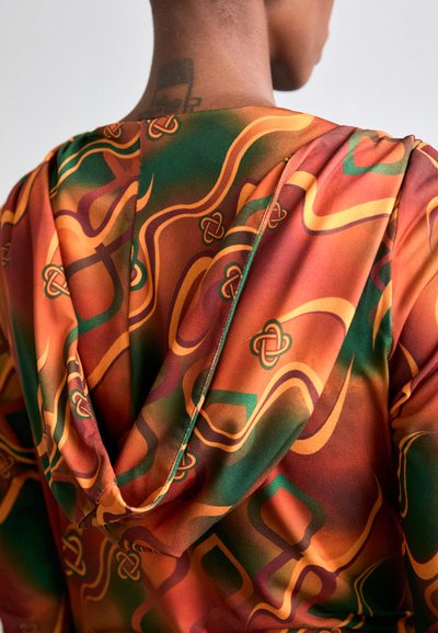 Hooded garment featuring a vibrant pattern with swirling lines in orange, brown, and green. Smooth texture and flowing design.