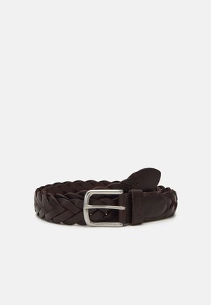 Ceinture en cuir tressé brun foncé avec boucle rectangulaire argentée, enroulée sur un fond blanc.
