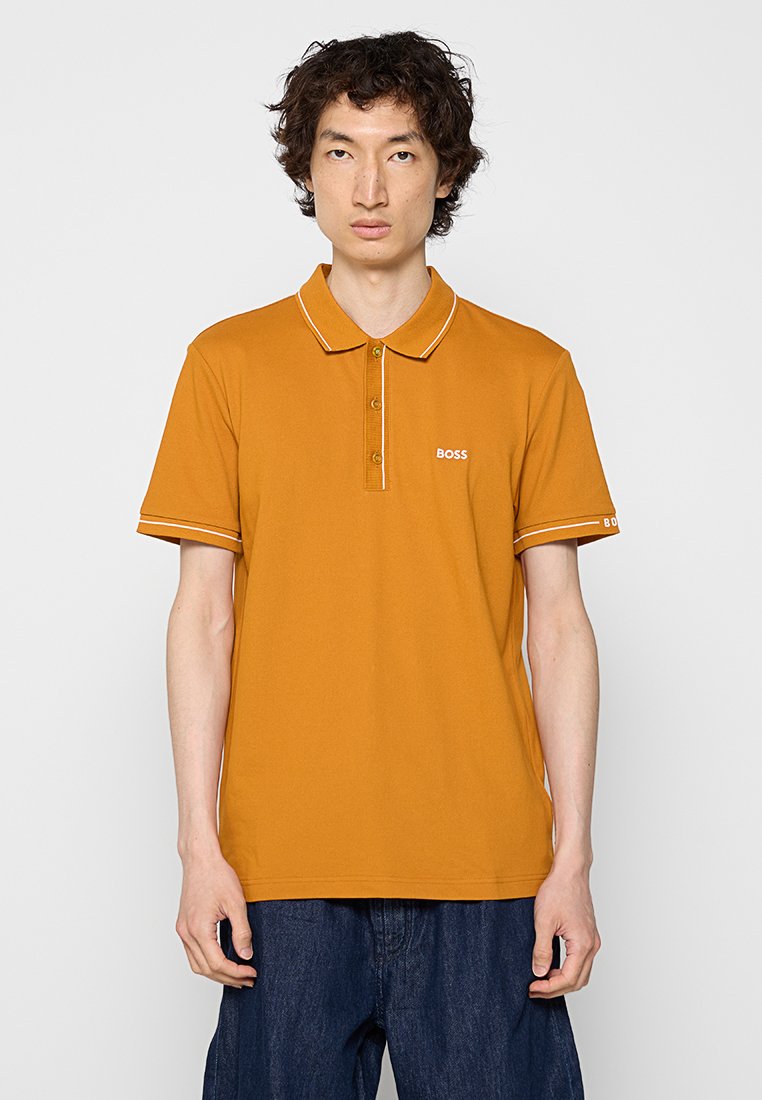 Polo shirt giallo senape in cotone, con colletto, doppio bottone e dettagli bianchi sulle maniche e sul logo.