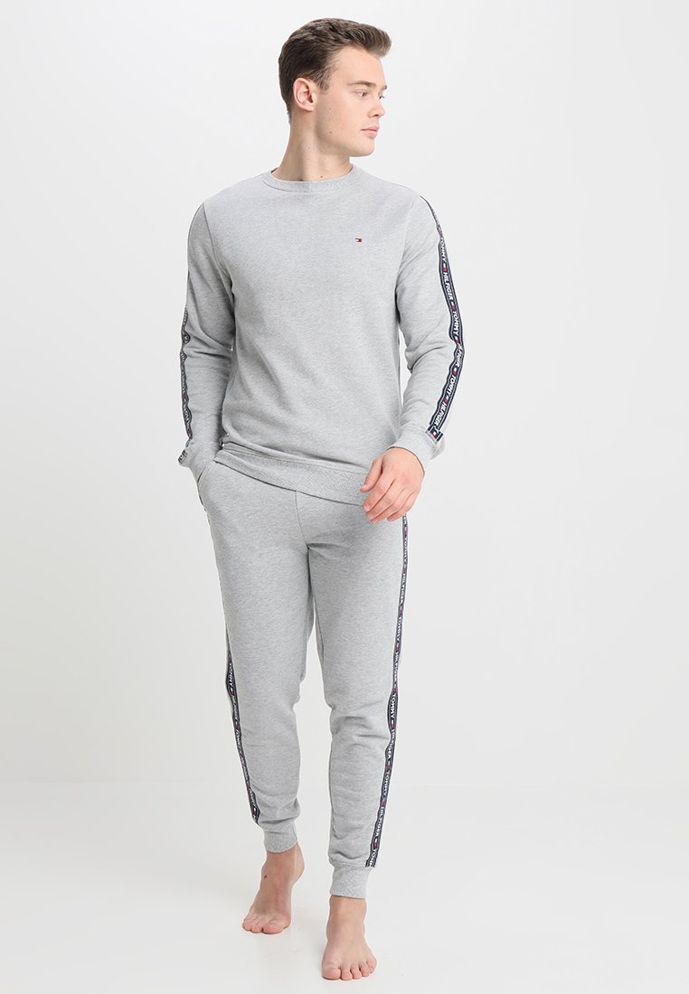Sweatshirt gris et jogging assorti en coton. Présente des accents de logo sur les côtés. Ajustement confortable avec des manches longues et des jambes fuselées.