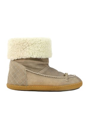 Bottine en daim brun clair avec revers en polaire crème, couture mocassin, petit nœud sur le devant et semelle en caoutchouc.