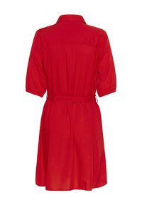 Czerwona sukienka z krótkim rękawem, z kołnierzykiem, z wcięciem w talii i marszczonym tyłem. Wykonana z lekkiego materiału o gładkiej fakturze.