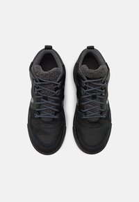 Czarne buty sportowe z teksturowanej tkaniny, szare sznurówki i puszyste wyściółki. Posiadają wygodny kołnierz i płaskie gumowe podeszwy zapewniające przyczepność.