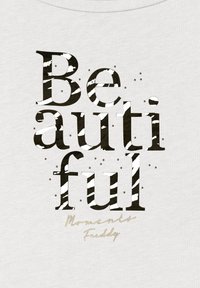 Un tessuto bianco con la parola "Beautiful" in lettere grasse, a righe nere e bianche, accompagnato da dettagli argentati che riportano "Moments Freddy."