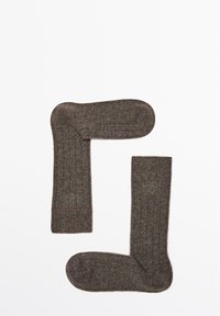 Hnědé žebrované ponožky z měkkého materiálu, s plochým pleteným lemem a hladkou texturou. Dvě ponožky jsou zobrazeny překrytě.