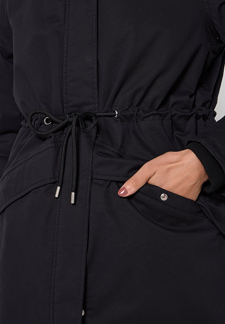 Zwarte houtje met een verstelbare trekkoord in de taille, elastische manchetten en twee voorzakken. Soepele stof met een waterafstotende finish.