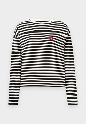 Crna i bijela prugasta majica dugih rukava s malim crvenim srcem koje ima natpis "The VIP Club" na lijevoj strani prsnog koša.