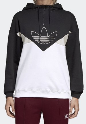 Sweat à capuche Adidas noir, blanc et beige avec une fermeture éclair devant et un logo, porté par une personne avec un pantalon Adidas bordeaux.