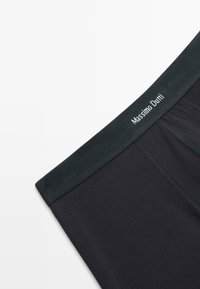 Černé bavlněné boxerky s elastickým páskem s žebrovaným vzorem, na kterém je bílý nápis "Massimo Dutti", vynikající hladkou texturou a přiléhavým střihem.