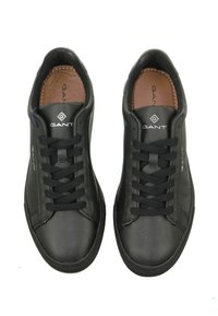 Schwarze Ledersneaker mit runden Zehen, schwarzen Schnürsenkeln und einem gepolsterten Kragen. Mit einem Logo an der Seite und einer glatten Textur.