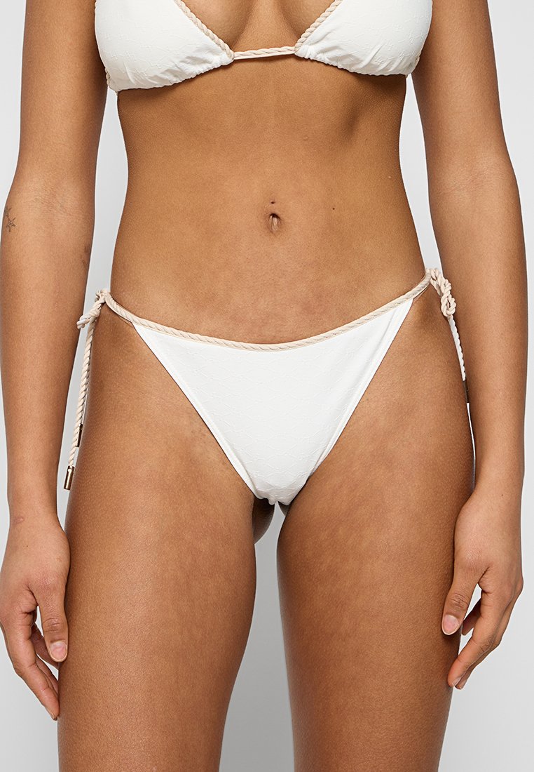 Weiße Bikinihöschen aus strukturiertem Stoff, seitliche Akzente mit beigem Seilband und minimalistisches Design. Klassischer Badeanzug-Stil.