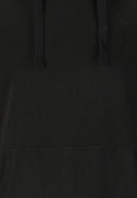 Mustat hupparit, joissa on näkyvät etutaskujen ompeleet, nyörikujat ja hillitty brodeerattu logo rinnassa.