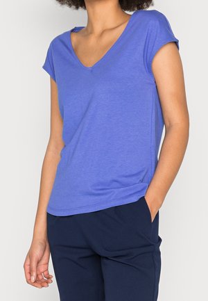 Fioletowy, krótki rękaw, T-shirt z dekoltem w serek, wykonany z gładkiej tkaniny, włożony do granatowych spodni z kieszeniami. Prosty design, wygodne dopasowanie.