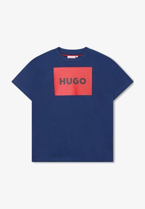Granatowy T-shirt z krótkim rękawem z czerwonym prostokątnym panelem z logo z czarnym napisem "HUGO", umieszczonym na środku klatki piersiowej.