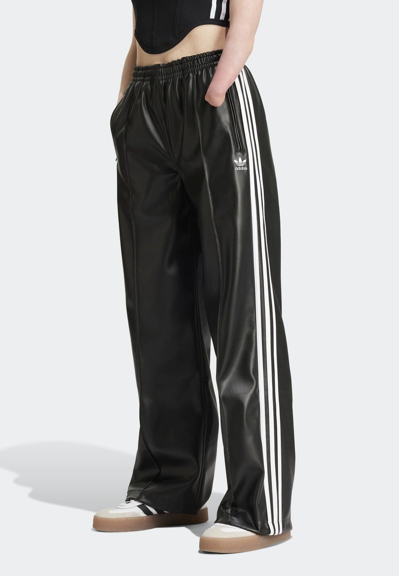 Svarta satinbyxor med elastisk midja, med tre vita ränder längs varje sida och en liten logotyp på underbenet.