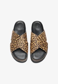 Sandalias de piso con estampado de leopardo, que presentan un diseño de tiras cruzadas, parte superior de cuero, plantilla negra y suela texturizada para mayor agarre.