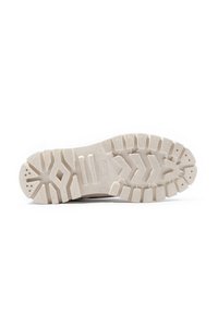 Semelle en caoutchouc blanc avec un motif de semelle prononcé, comportant des crêtes et des rainures pour une meilleure traction. Texture lisse avec un détail de logo en relief.