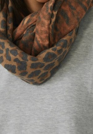 Bruin en zwart sjaaltje met luipaardprint om de hals gewikkeld over een lichtgrijze top, close-up die de textuur en plooien van de stof laat zien.