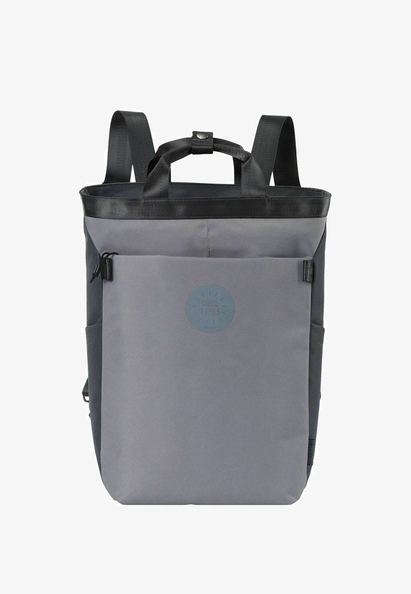 Gray backpack with a rectangular shape, made of durable fabric, featuring black straps, a top handle, and a prominent circular logo.
