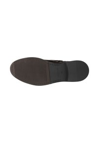 Semelle d'une chaussure habillée pour homme avec des zones de grip texturées et un talon lisse, en tons marron foncé et noir, taille 42 indiquée.