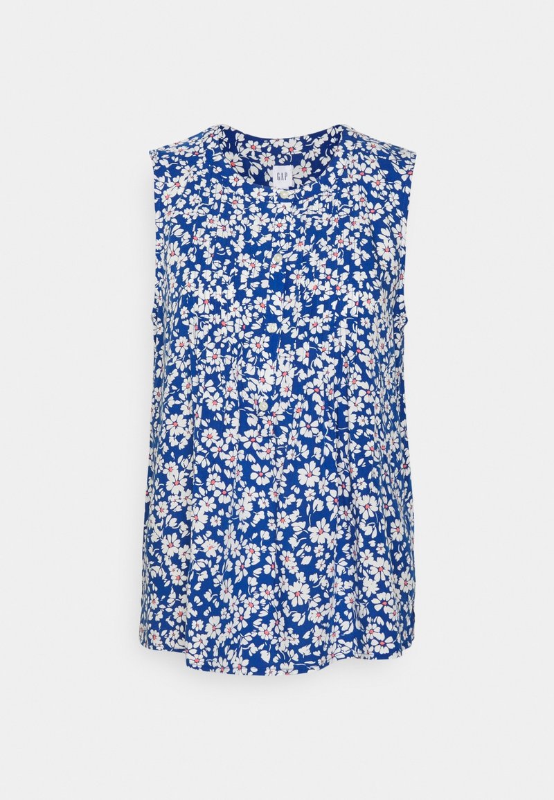 Haut sans manches bleu arborant un motif floral avec des fleurs blanches et rouges. Le tissu est léger, avec une coupe décontractée et des détails plissés.