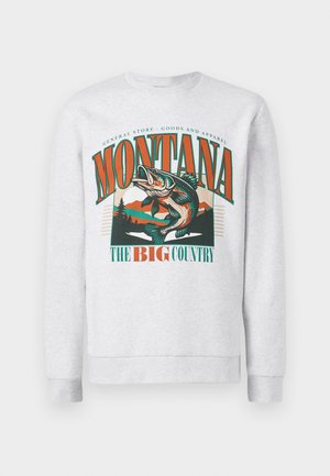 Sweatshirt gris clair avec un grand graphique d'un poisson sautant, des montagnes et des arbres, avec le texte "Montana The Big Country" en orange et vert.