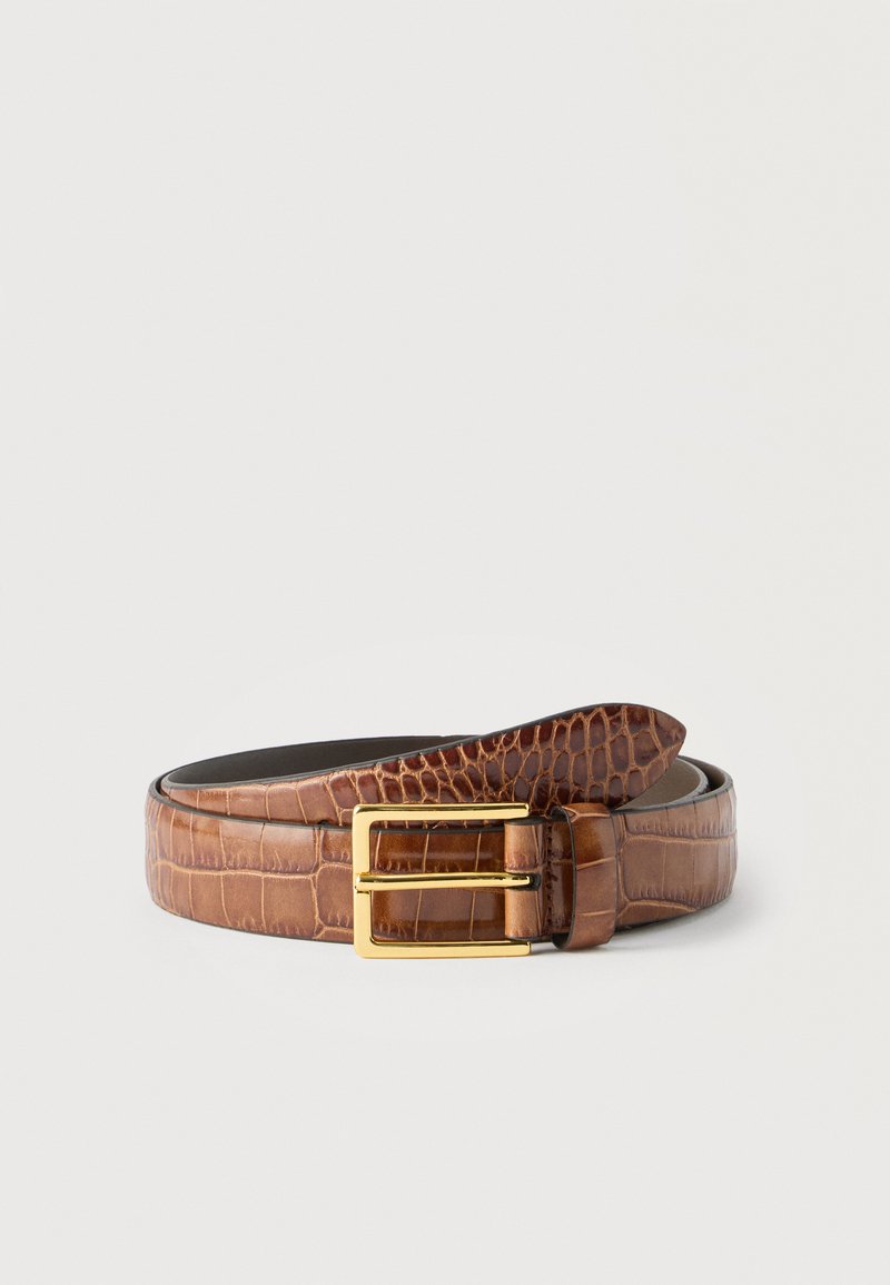 Ceinture en cuir marron à motif crocodile enroulée avec une boucle rectangulaire dorée sur un fond blanc uni.