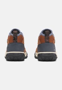 Scarpe da trekking marroni e grigie con tomaia in rete, collo imbottito e suola in gomma texturizzata. Logo prominente sul tallone e accenti decorativi.