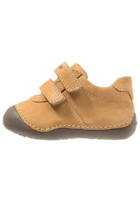Scarpa per bambini in suede beige con due cinturini in velcro, punta rotonda, cuciture bianche a contrasto e suola in gomma grigia.