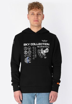 Schwarzer Hoodie mit grafischem Druck und luftfahrtbezogenen Designs. Enthält eine Kängurutasche und ein kontrastierendes oranges Etikett am Ärmel.