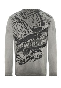 Langärmliges T-Shirt in verblasstem Grau mit schwarzem graphischem Text und Designs. Hat einen Rundhalsausschnitt und ausgefranste Ärmeldetails.