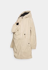 Veste beige à capuche avec fermeture éclair frontale et poche latérale, avec une poche attachée pour porter un bébé ou un jeune enfant.