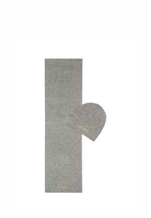 Set di sciarpa lavorata a maglia grigio chiaro e berretto abbinato con scritte dorate sottili su sfondo bianco.