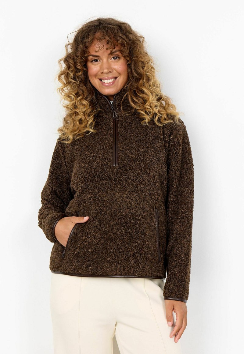 Brun fleece-pull med hög krage, dragkedja i halsen, långa ärmar och sidofickor. Texturerad tyg med släta bruna accenter.