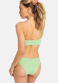 Zöld, bordázott, egyvállas bikini felső, hozzáillő magas derekú alsóval. Az anyag textúrált, illeszkedő kialakítással bír, minimális fémalkatrészekkel.