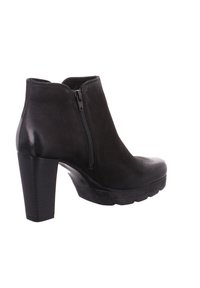Bottine en cuir noir avec talon bloc haut et fermeture éclair latérale, dotée d'une semelle texturée antidérapante.