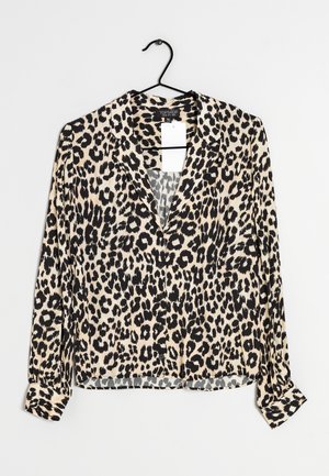 Leopardenmuster-Bluse mit langen Ärmeln, V-Ausschnitt, weichem Stoff, hellbeigem Hintergrund und schwarzen Flecken. Hat knöpfbare Manschetten und einen Aufhänger.