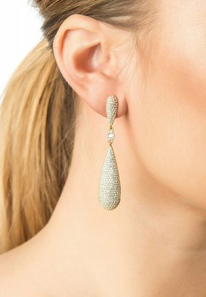 Gold teardrop earrings with textured surface, featuring a sparkling clear gemstone accent. Length reaches just below the earlobe.