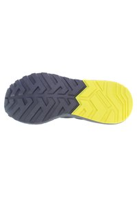 Gummisula med ett zigzag-mönster; mörkgrå med gula detaljer på hälen. Hållbar, designad för grepp och stabilitet.