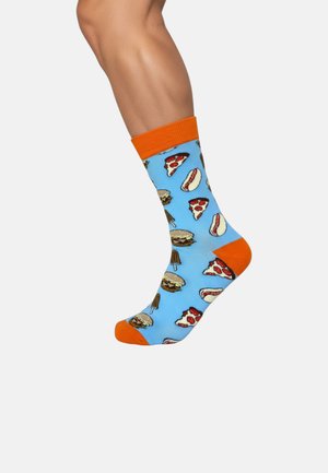 Niebieskie skarpetki z wzorami jedzenia, w tym pizzą, burgerami i hot dogami. Posiadają pomarańczowe mankiety i palce, wykonane z miękkiego materiału.