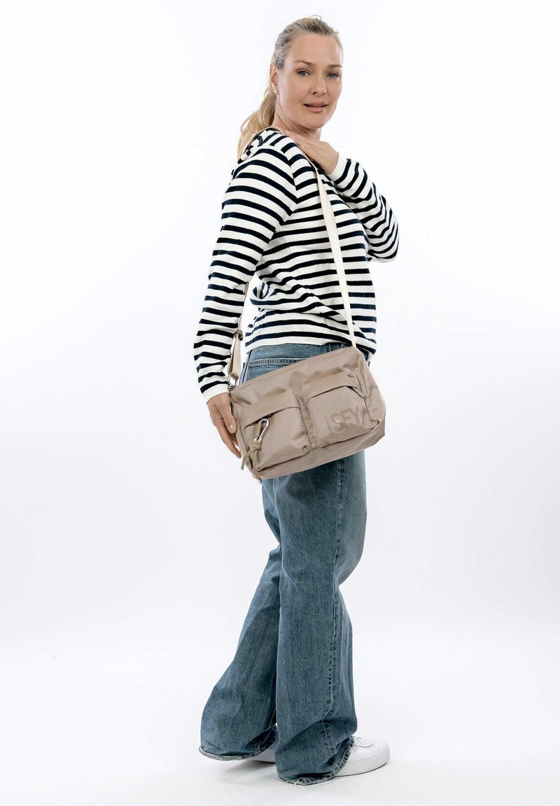Borsa a spalla beige con due tasche frontali, in materiale tessile, tracolla regolabile e dettagli con zip, mostrata su uno sfondo neutro.