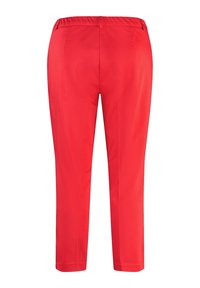 Pantalon rouge fuselé avec une taille élastique, une texture lisse et sans poches visibles, présentant un design épuré et simple.
