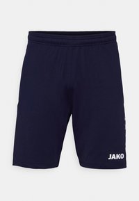 Pantaloni sportivi navy con elastico in vita, caratterizzati da un logo JAKO bianco sul lato sinistro inferiore. Tessuto di superficie liscia, design lungo fino al ginocchio.