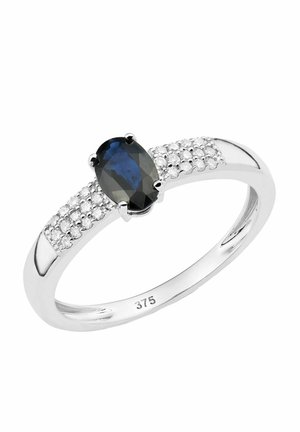 Sapphire gredzens ar ovālu centrālo akmeni, apkārt mazākiem caurspīdīgiem akmeņiem uz pulēta sudraba joslas. Atzīmēts ar "375" zelta tīrības zīmi.