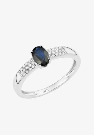 Safirni prstan z ovalnim osrednjim kamnom, obdan z manjšimi prozornimi kamni na poliranem srebrnem traku. Oznaka "375" označuje čistoto zlata.