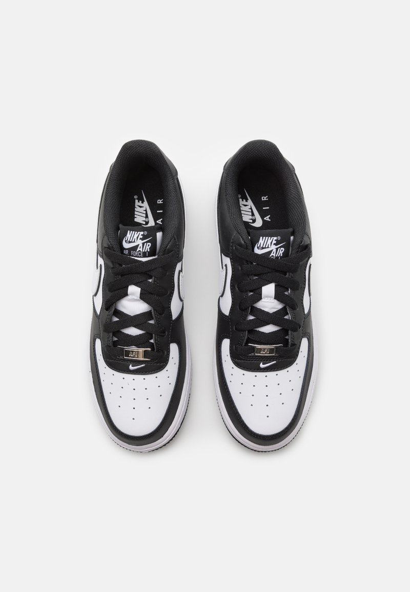 Le sneakers Nike Air Force 1 presentano un design bianco e nero, materiale in pelle, punta rotonda, tomaia perforata e lacci neri con dettagli metallici.