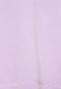 Tessuto morbido di colore viola chiaro con una superficie liscia. Il design è semplice, con dettagli di cucitura visibili lungo l'orlo inferiore.