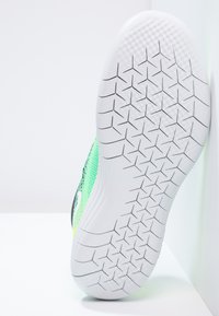 Atletická obuv s horní částí z zelené síťoviny a bílou gumovou podešví. Obsahuje texturovaný vzor pro přilnavost a zakřivený design paty.