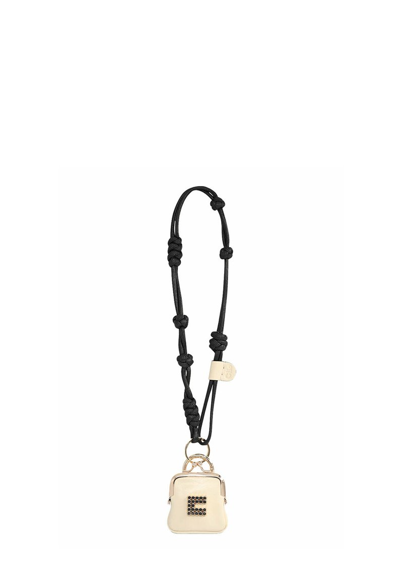 Sac compact de couleur crème avec une sangle noire, doté d'une fermeture éclair et d'un détail en métal. Le devant présente une lettre décorative « E ».
