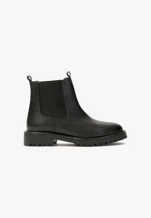 Bottines Chelsea en cuir noir avec panneaux élastiques sur les côtés, languettes de tirage et semelle en caoutchouc épaisse dotée d'un motif de semelle texturé.